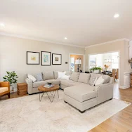 Clean living room with light carpet and sectional sofa after Sano Steam carpet cleaning — Anne Leanos review