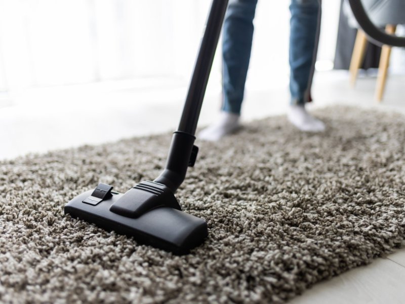 people housework housekeeping concept close up woman with legs vacuum cleaner cleaning carpet home c 1